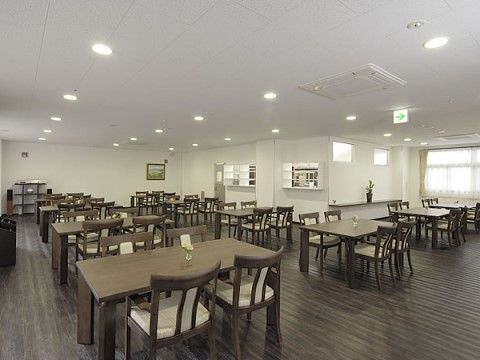 広々としたリビングには深い木の色合いの床に家具がゆったりと配置されている。入居者様が車椅子でもご移動しやすく快適にお過ごしいただける。