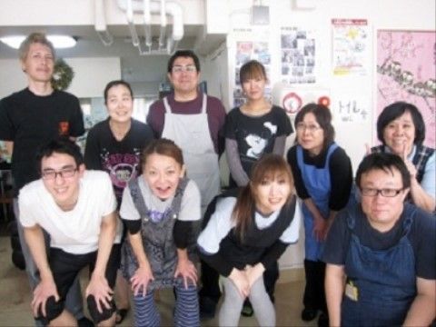 年代や性別がさまざまな、和気あいあいとポーズをとるスタッフ