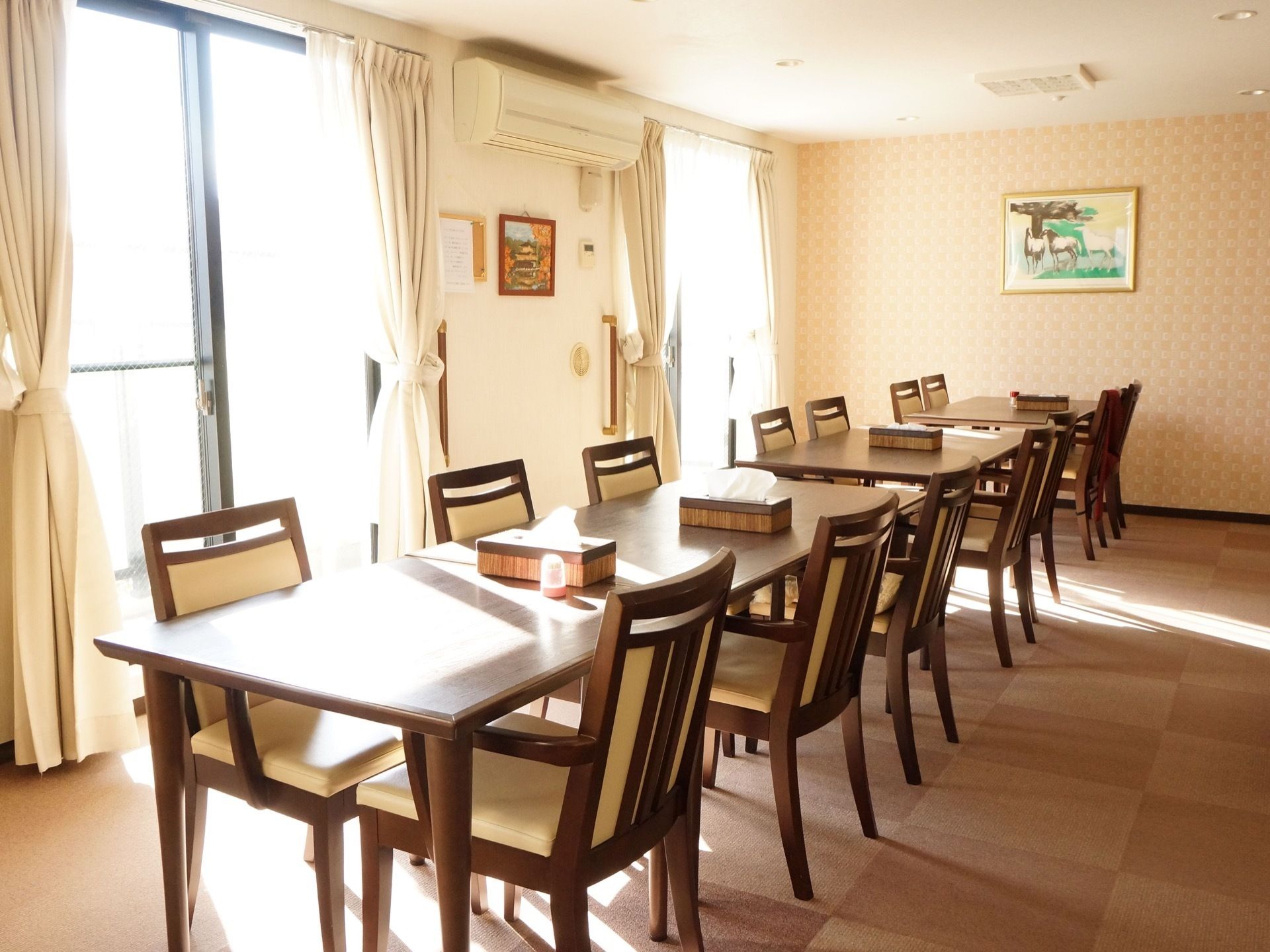 白を基調とした部屋に、ダークブラウンの家具があり、落ち着いた雰囲気である。入居者様が自由に利用できる場である。