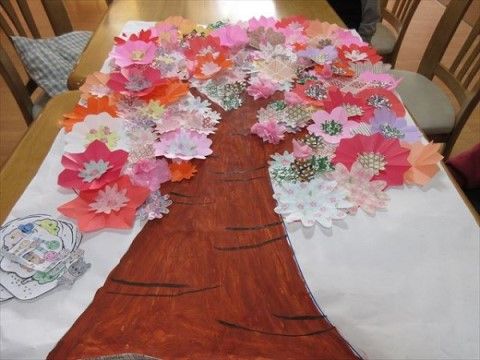 折り紙の花をたくさん張り付け、桜の木に見立てた手作りの壁面装飾