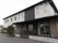 京都市営バスの菱川バス停から歩いて5分、西羽束師川に面した通りに建つ。黒が基調の低層建築は、周辺環境に馴染んでいる。