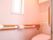 トイレは引き戸仕様になっていて、壁や便器がピンクの温かみのある色になっている。また、手すりが付いている。