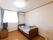 日当たりが良い個室である。部屋にはベッドに寝具が用意されており、テレビや収納棚が設置されている。床はフローリングである。