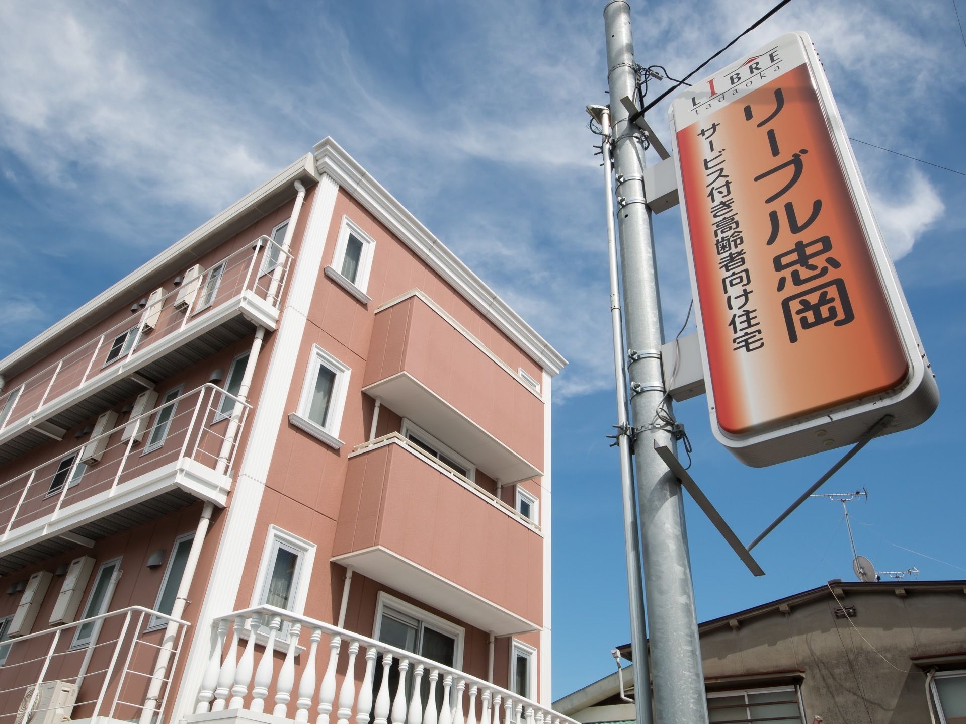 白くエレガントなデザインの窓枠や手すりが施された建物。縦長の細い窓が洋風建築の雰囲気を醸し出している。