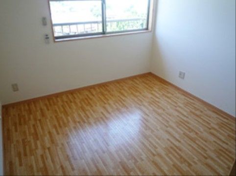 白い壁にフローリングの部屋。窓があり昼間は光が入り明るい。コンセントの差し込み口が２箇所に取り付けられている。