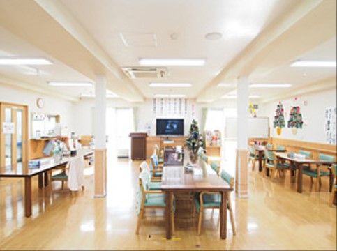 広い空間にはテーブルと椅子がいくつも配置されている。壁には手作りの飾りが張られている。窓の近くにはテレビが置いてある。