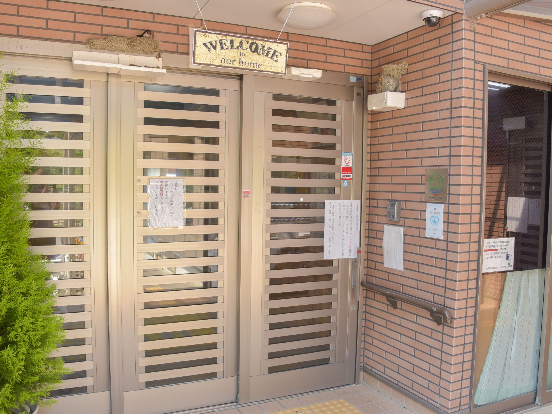 玄関部分には英語で書かれた看板が入居者達を出迎えてくれ、洋風のコテージのような雰囲気を漂わせている。