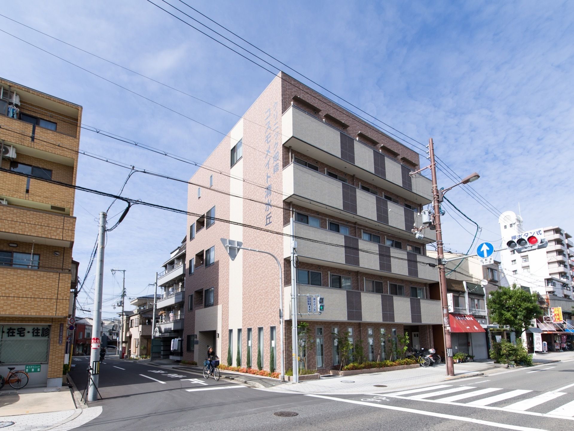 通りに面しているが、周囲は住宅が多くある。目の前は横断歩道になっている。建物の壁面に大きく施設名が書かれている為、遠くからでも解り易い。