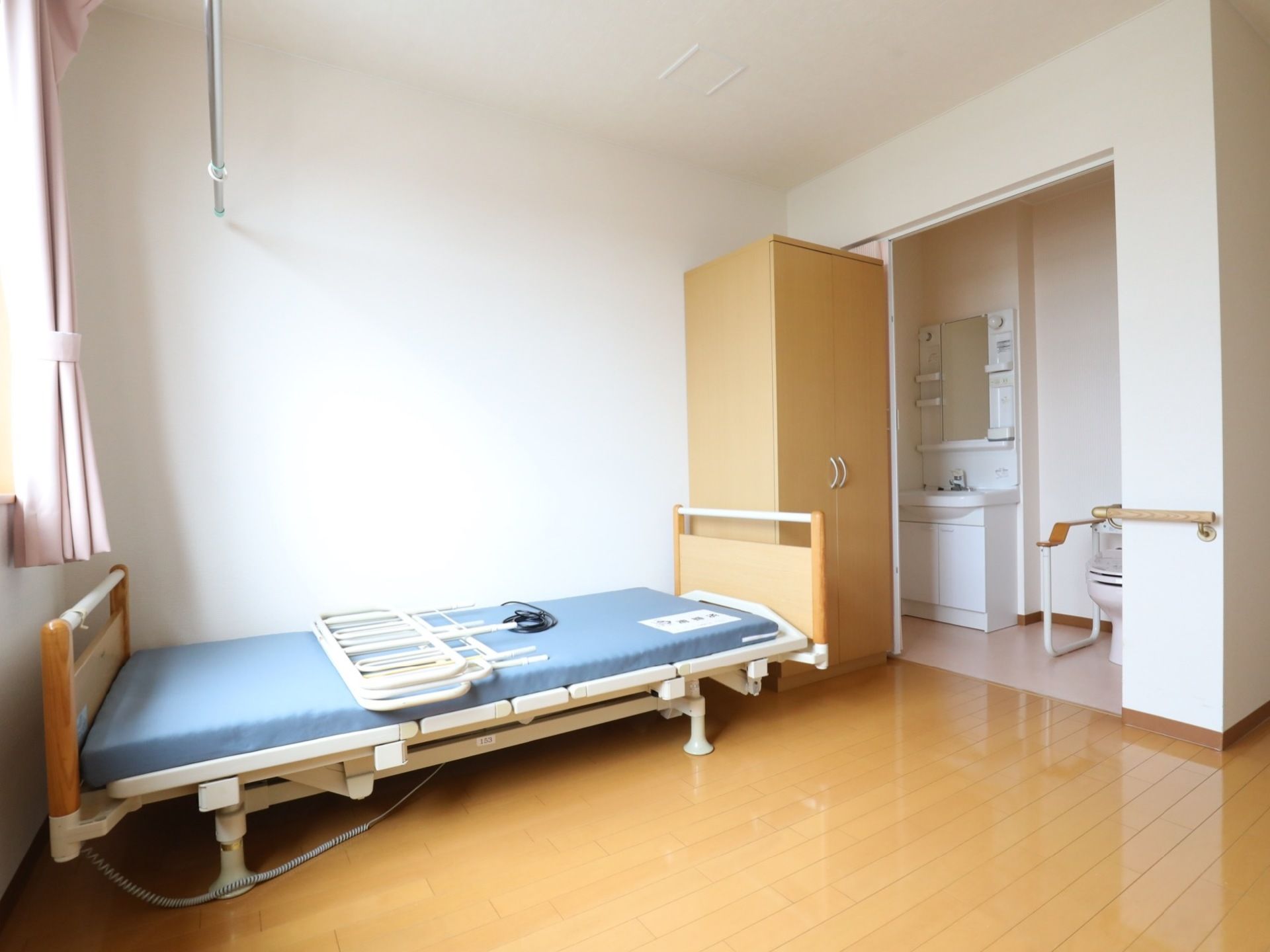 窓のある居室には介護用ベッドやクローゼットが設置されている。別スペースには、トイレや洗面台が完備されている。