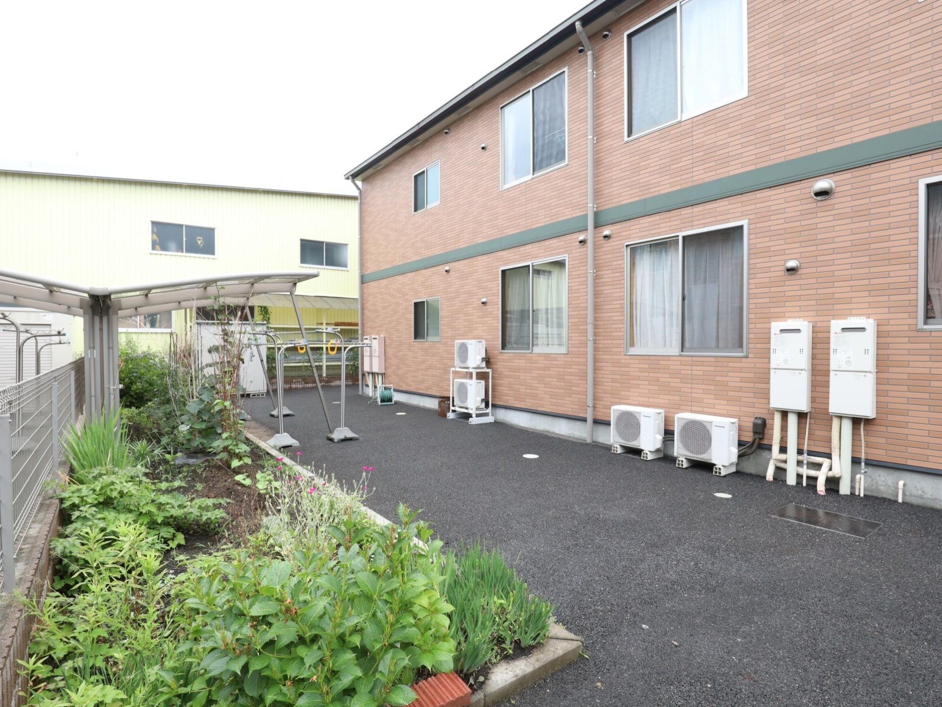 建物の裏手に設けられ、多種多様な植物が育てられている花壇