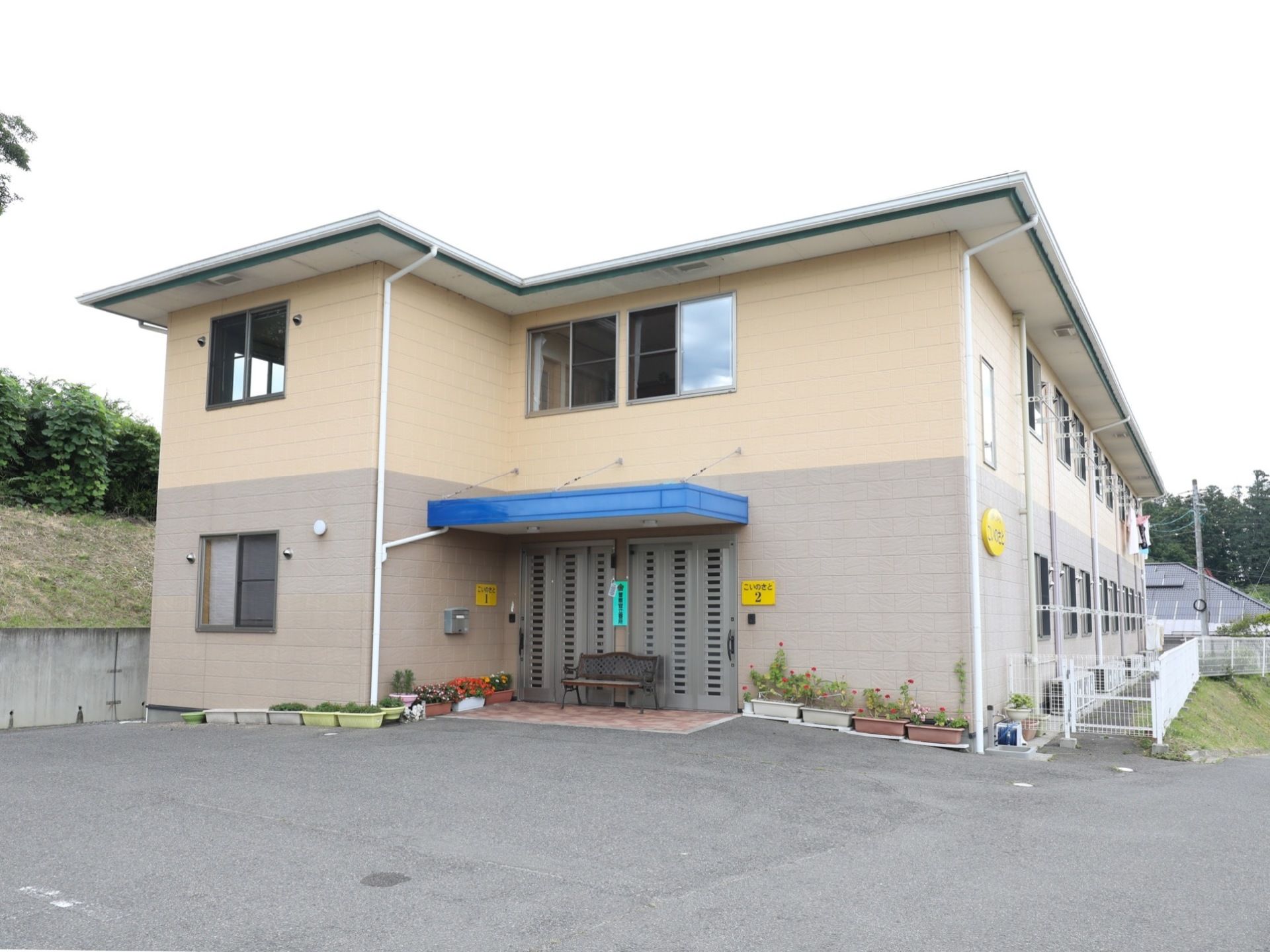 大きめのアパートのような建物である。外壁は淡いグレーとベージュのツートンカラーで親しみやすさを醸し出している。