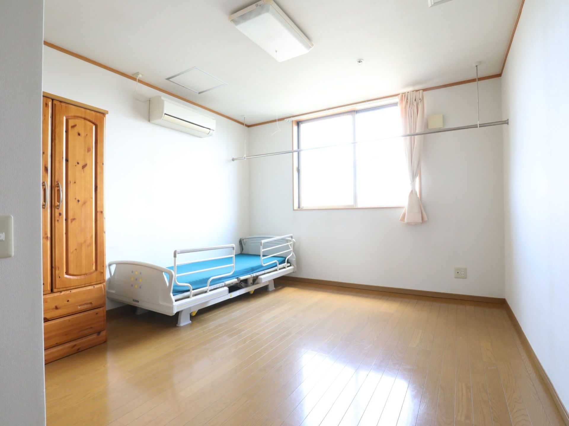 広い空間の居室である。窓際には物干し竿が設置されており、入居者様は洗濯物などを速やかに干すことができる。