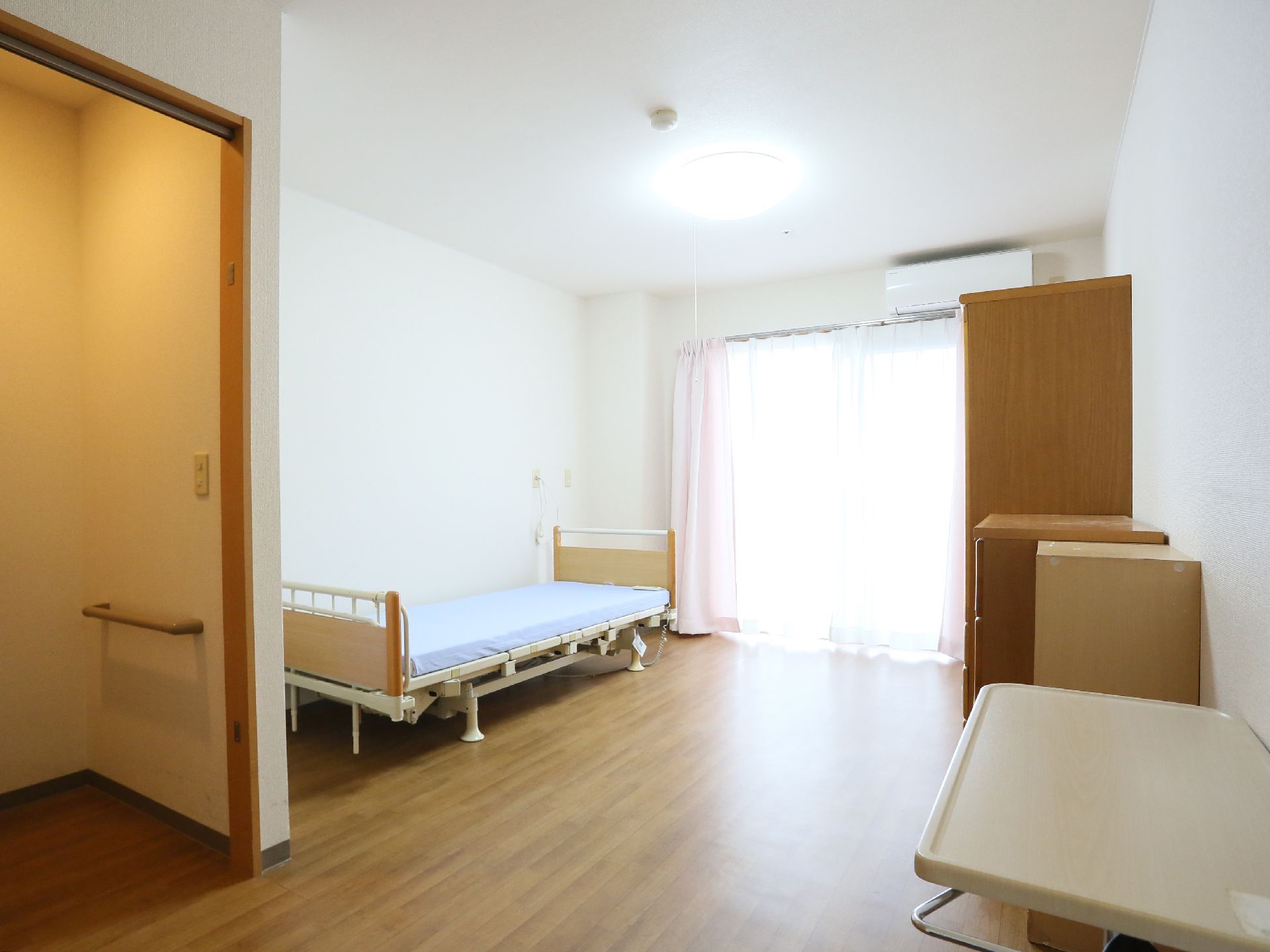 居室は広く、大きな窓がある。ベッド、二竿のタンス、サイドテーブルが置かれている。ベッドの足元側には壁に手すりがつけられた個室がある。