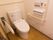 花柄の壁紙が愛らしいトイレである。清掃が行き届き清潔感がある。ナースコールや手すりが完備されている。
