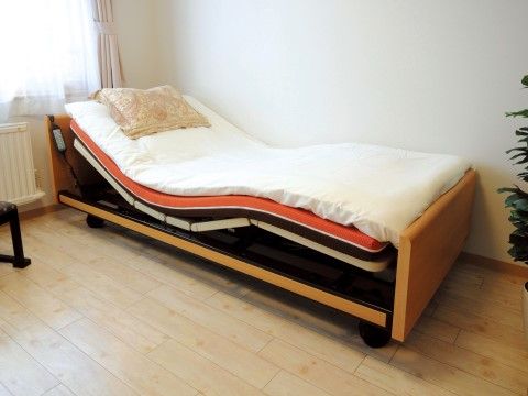 簡単にリクライニングできる介護用の電動ベッド。ベッドにもたれながら、体を楽に起こして過ごすことができる。
