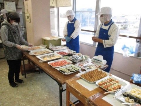 たくさんの料理がバイキング形式で並べられ、配膳の準備をしているスタッフの様子