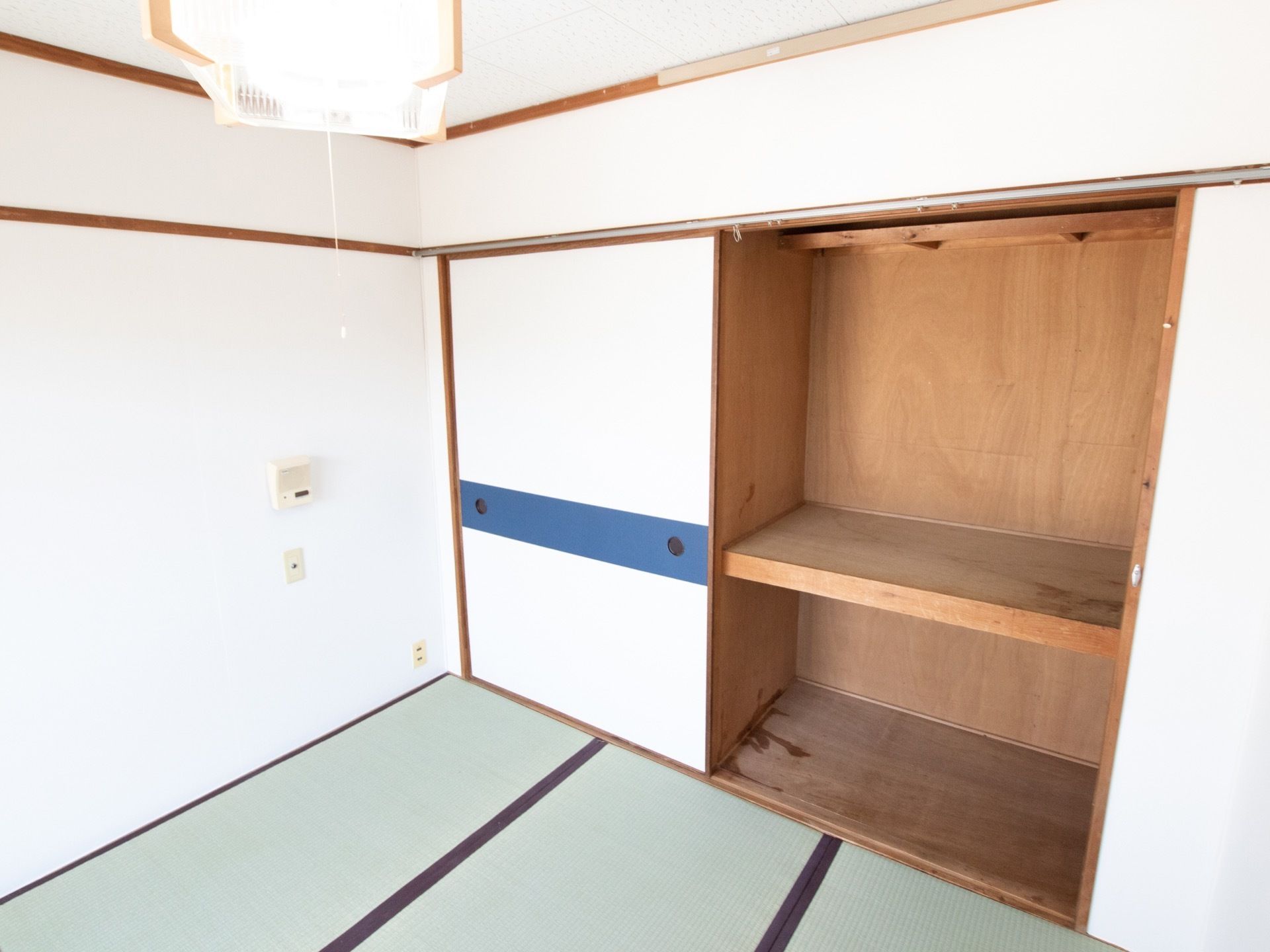 畳敷きの居室には広々とした押入れが設置されている。上下２段に別れていて、青いラインの入った襖が取り付けられている。