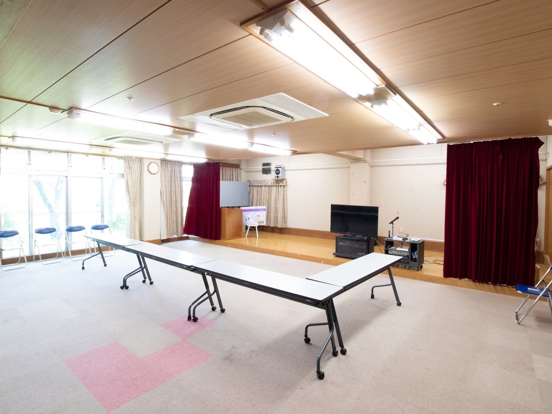 広々とした施設内の集会室である。ステージがあり、スタッフと入居者様でカラオケなどのレクリエーション活動をしている。