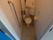 きれいに清掃された清潔感のあるトイレである。壁には安全のためのＬ字型の手すりとナースコールが設置されている。