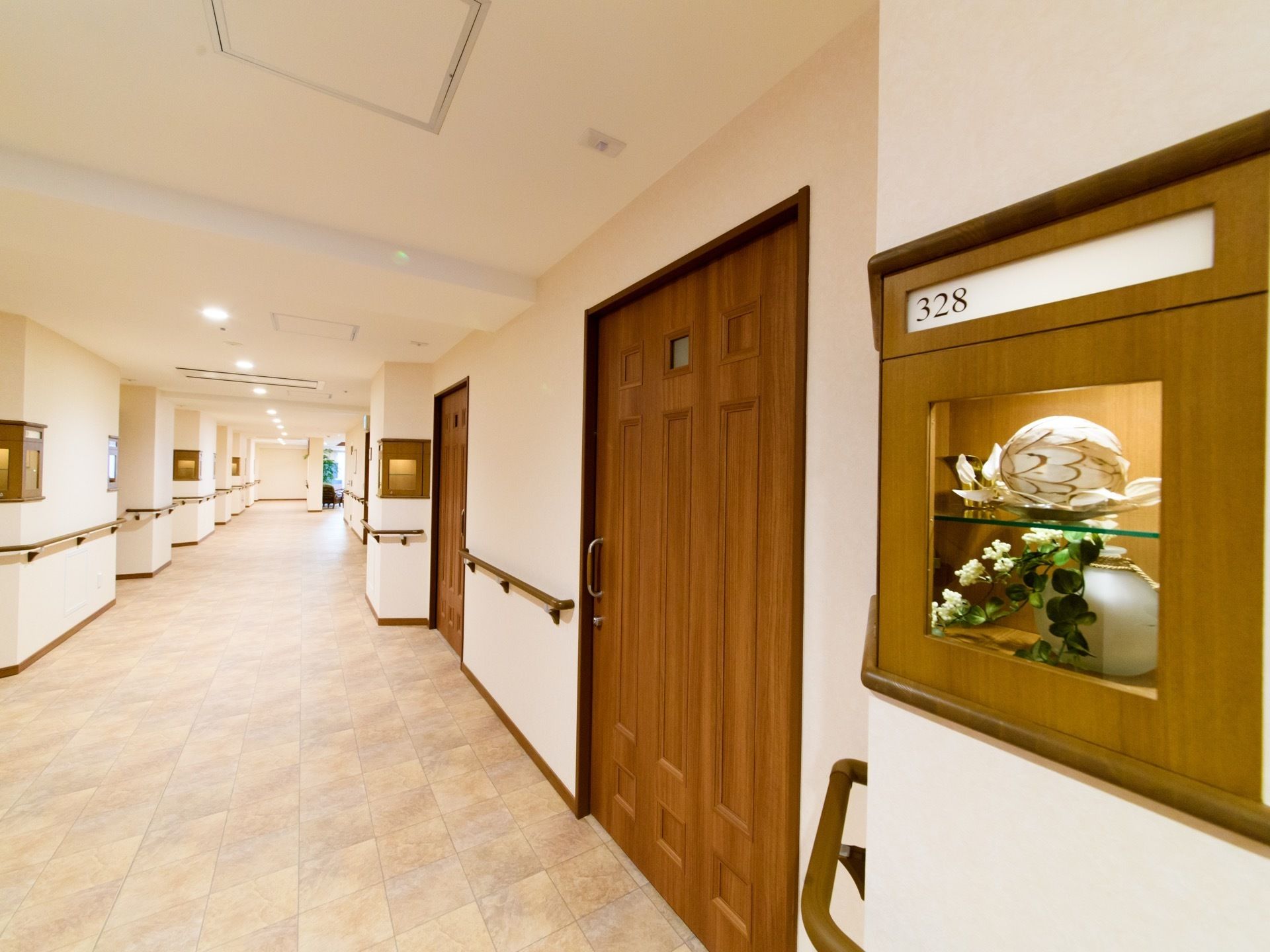 幅の広い共有部の左右に居室がある。居室のドアは重厚感のあるデザインの引き戸になっている。ドア横には飾り棚付きの部屋ナンバープレ―トがある