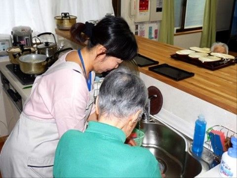 キッチンでスタッフと一緒に、簡単な調理を行う入居者様の模様