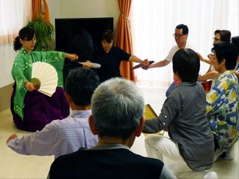 袴姿で扇子を持った講師による、舞踊の講習を受ける入居者様の様子