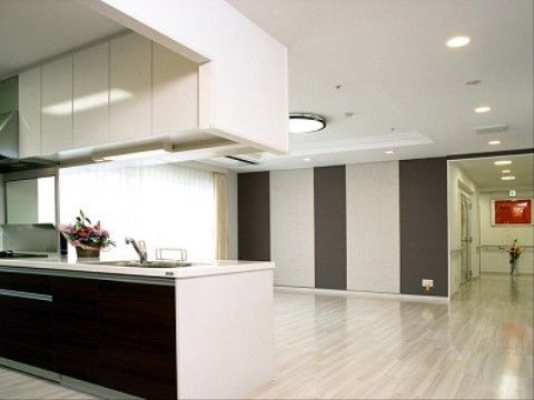 大きな窓があり、床はフローリングになっている。壁は白色と茶色系に色分けされており、天井には照明設備が完備されている。