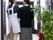 廊下の真ん中に女性２人が寄り添いながら立っている。壁際に観葉植物と消火器を置いている。防災設備を整えている。