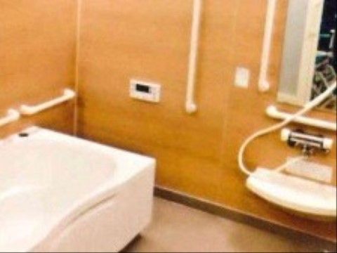 浴室の壁は木目調のような温かなデザインになっている。手すりが付いており、洗い場と浴槽の移動も安全に行うことができる。