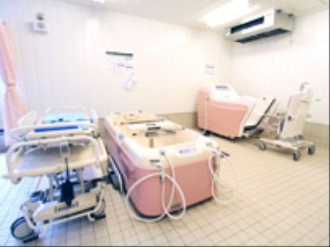 タイル貼りの浴室に、特殊介護浴槽が２台置かれている。座位浴、寝位浴が可能で、電動リフトも連結している。