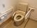 トイレの便座には、洗浄暖房機能がついている。横方向の手すりが壁に設置されていて、その上には呼び出しボタンがある。