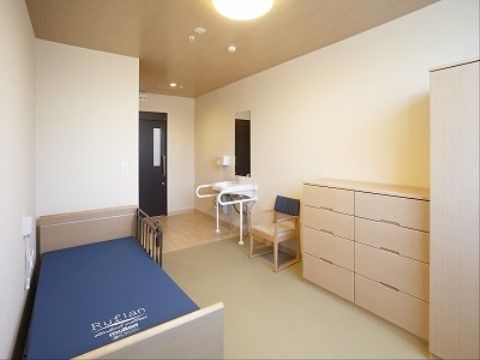 入口から部屋の奥まで続く幅の広い通路に、車椅子対応の洗面台を完備。８段ある大容量の収納タンスがある。動線を遮るものがなく、生活しやすい。