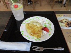 生クリームとバナナや苺を添えたパンケーキと、チェリーとレモンを浮かべたジュース