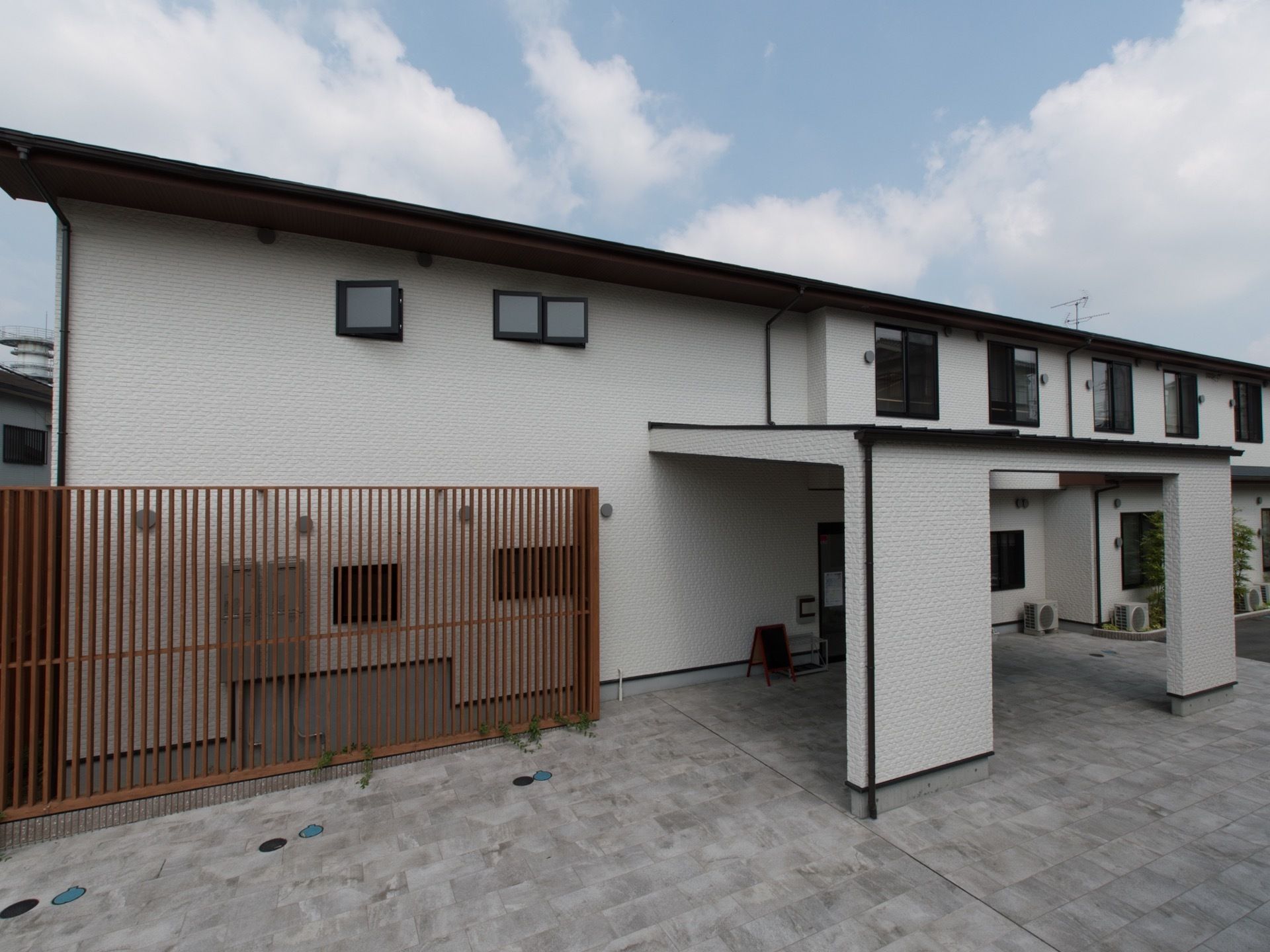 白色を基調とした外壁に、黒色の窓枠や縁どりが映えている２階建ての施設である。玄関には大きな車寄せがある。