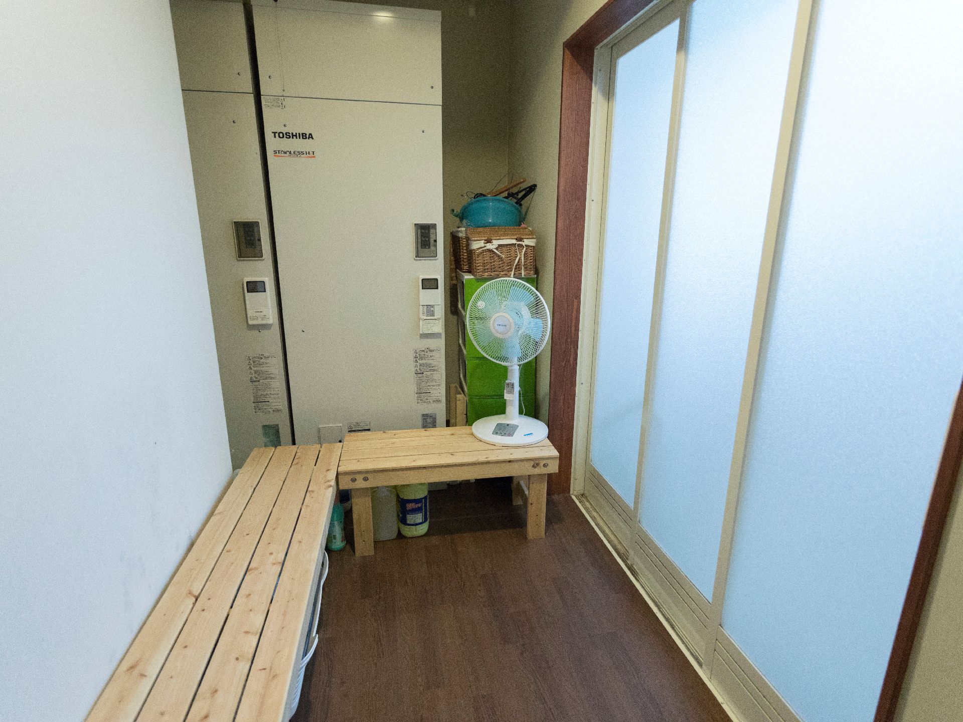 L字型に置かれたすのこベンチが脱衣所に備え付けられている。用意されている扇風機を使って涼むこともできる。