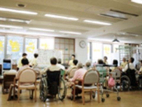 ホワイトボードでスタッフが説明し、それを熱心に聞く入居者様の様子