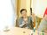手前にはテーブルがある。その上には受け皿に乗ったカップが置かれている。左側には窓があり、カーテンが付いている。