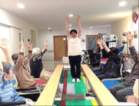 平行棒を囲んで、スタッフの指導に従いながらリハビリに励む入居者様たち