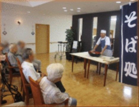 そば打ちショーが行われ、目の前でそばが出来上がる様子を見学している入居者様