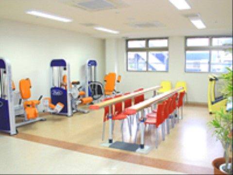 機能訓練室に、さまざまな運動を補助する装置が用意している。平行棒があり、歩行の訓練などに利用できる。