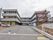 地上３階建ての鉄骨造りの赤色や黄土色などを配色したモダンな建物。敷地１階部分には大きな駐車場がある。