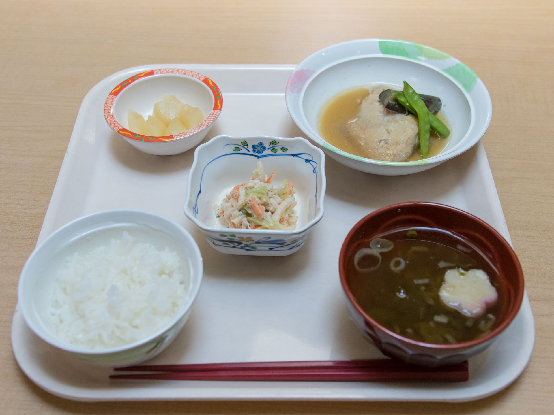 お盆にのせられた一人分の食事。ご飯と汁物の他、主菜一品と副菜二品が用意されている。それぞれの器には違う模様が描かれている。