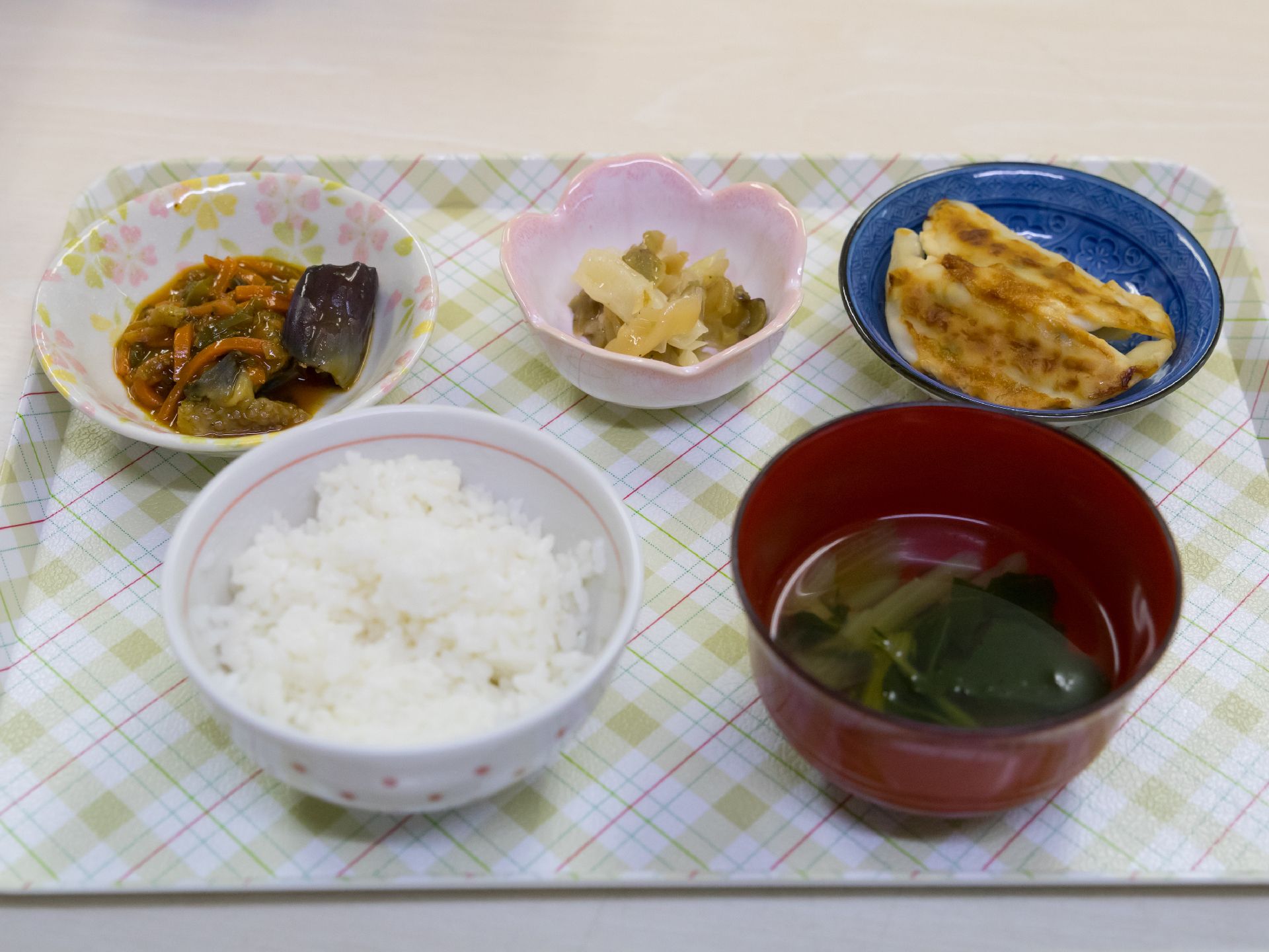 可愛らしいチェック柄のお盆の上には、お年寄りが好みそうな食事が用意されている。栄養バランスが考えられたメニューになっている。