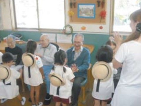 近隣の園児たちとの交流を、朗らかな表情で楽しんでいる入居者様の様子