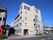 施設は5階建てのしっかりした建物で、通りの角にたてられている。外からは施設の部屋の窓が数多くみえる。