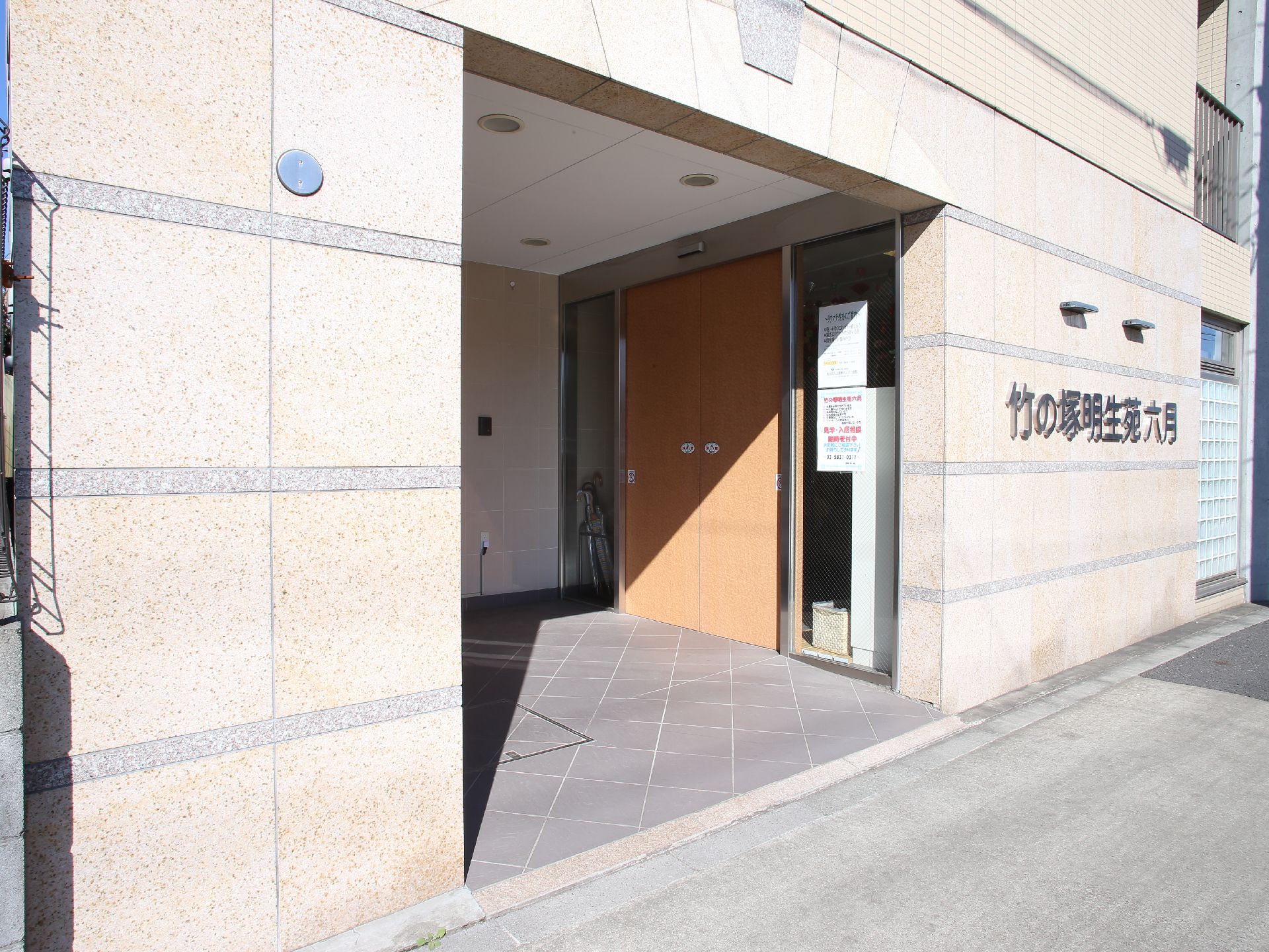 施設入口前の壁には、施設名が大きく銀色で印字されている。段差のないフラットな床なので、車椅子の方でも安心。