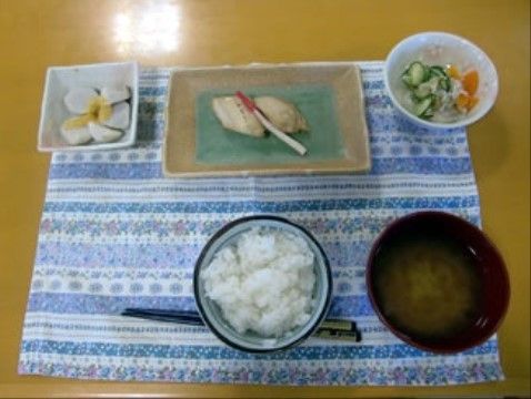 青と白のボーダー柄のランチョンマットに、煮物や焼き魚、ご飯とお味噌汁などが並んでいる