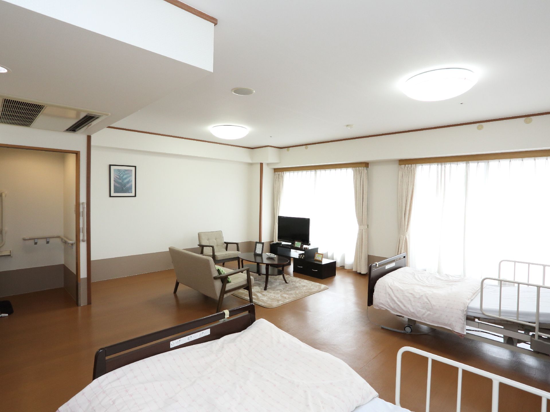 大きな窓から日差しが差し込む明るく広い部屋には、テレビ、ソファセットがあるので、入居者はゆったりとした時間を過ごせる。