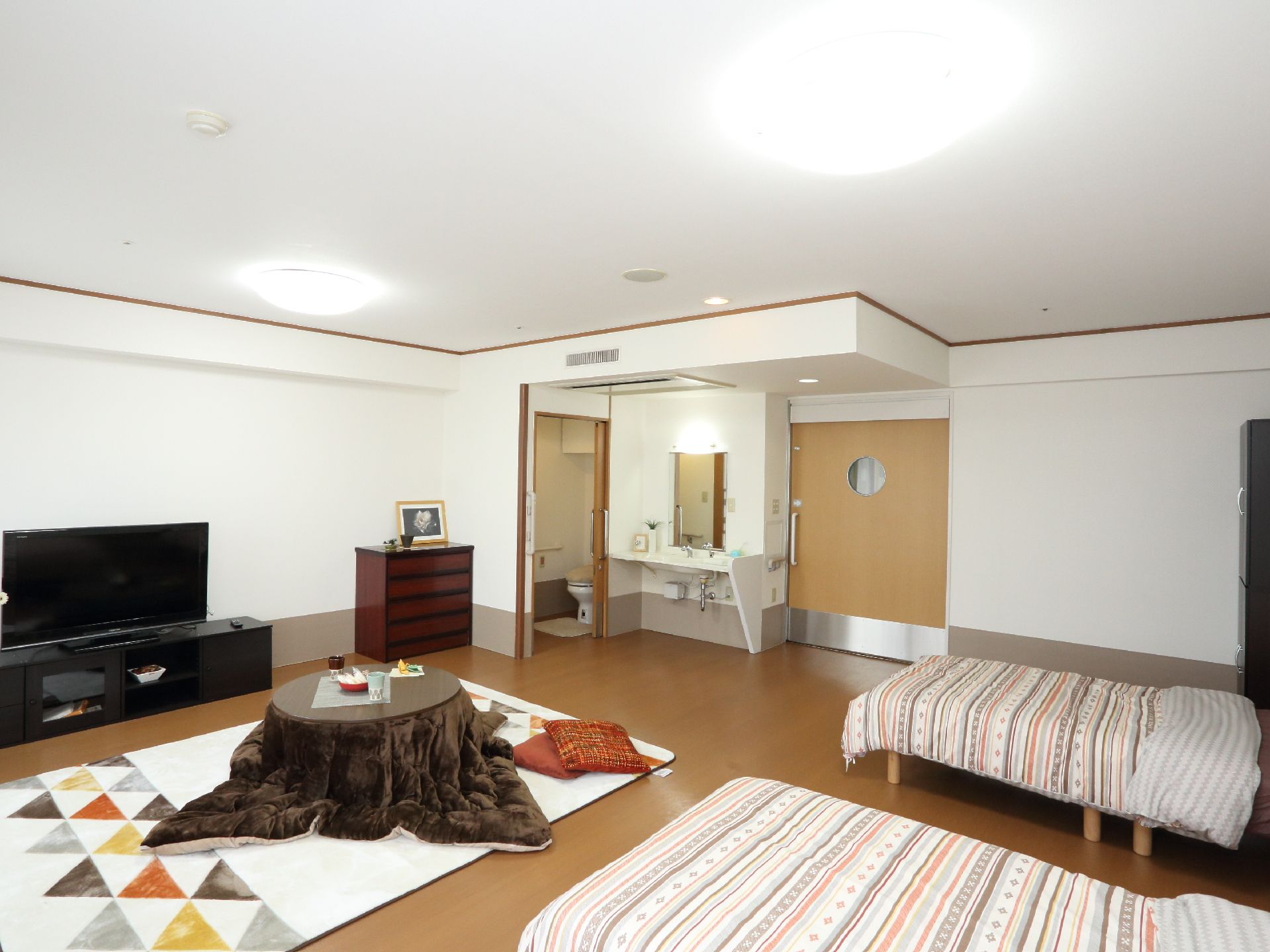 2人での利用ができる居室。トイレや洗面台も居室内の端に設置されている。出入りする扉は大きくスライド式である。
