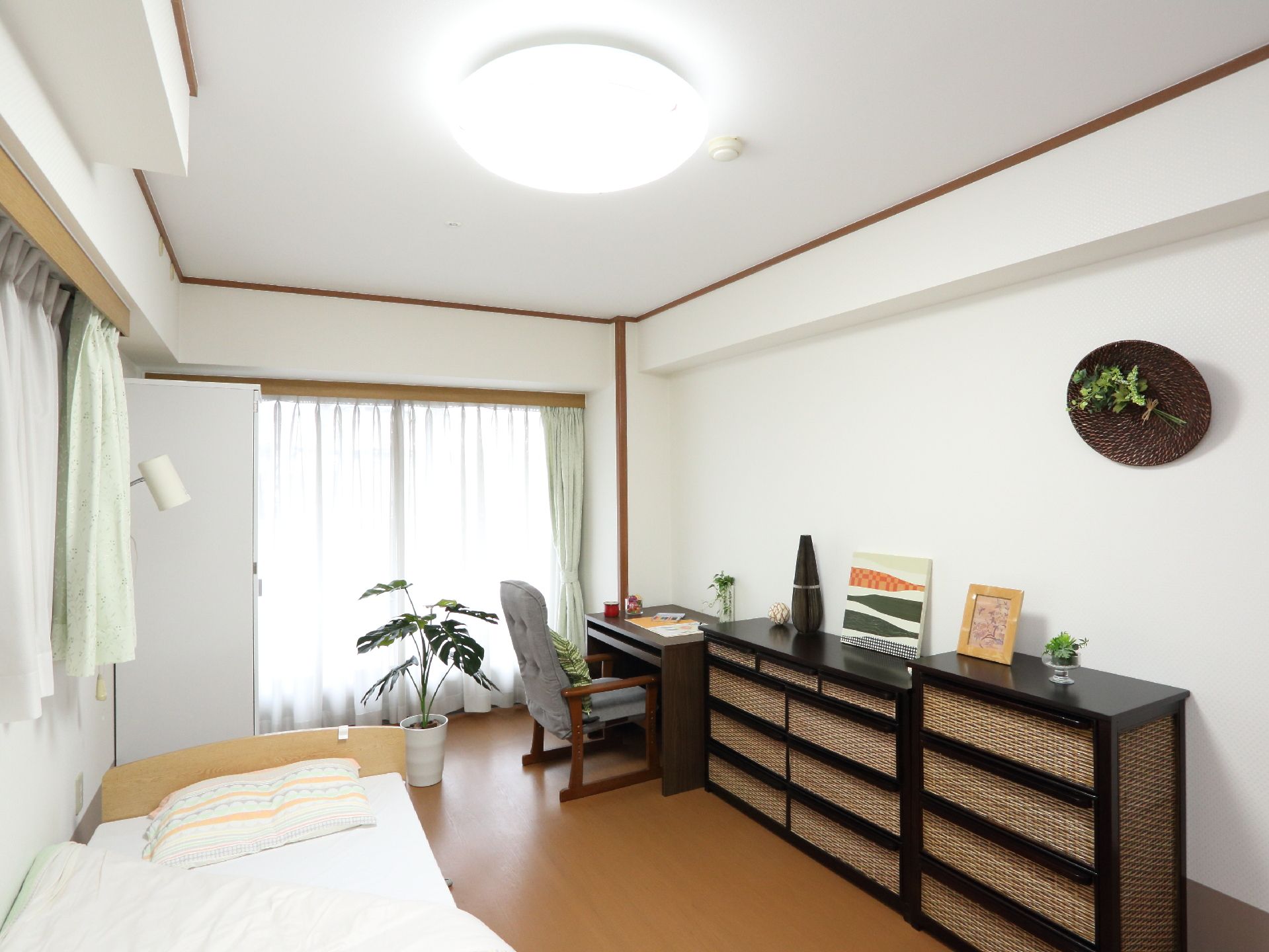 居室には、机や椅子も置いており、たくさん収納ができるチェストもある。ナチュラルな材質を使用した家具でそろえた居室である。